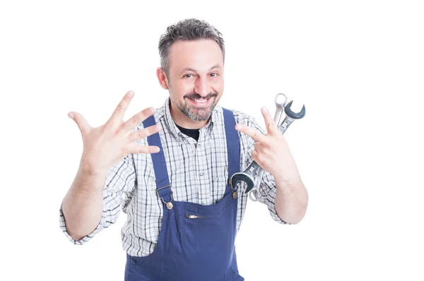 Cheerful handsome mechanic with wrench showing or counting seven — Stock Photo, Image