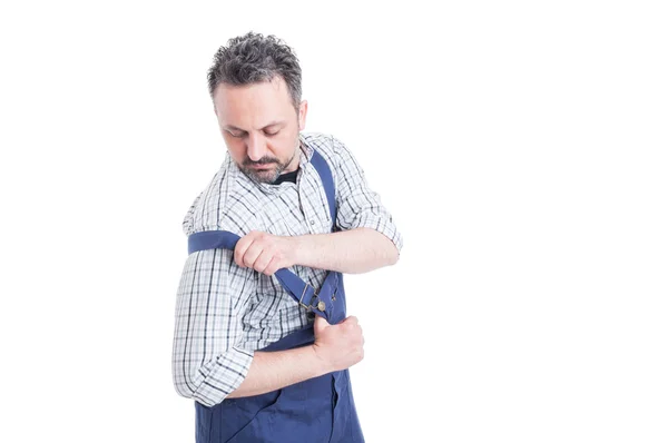 Handsome mechanic putting on his overalls for work — Stock Photo, Image