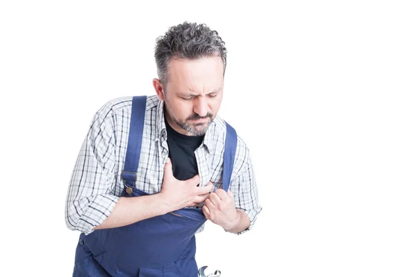 Młody mechanik o ból w klatce piersiowej i kołatanie serca — Zdjęcie stockowe