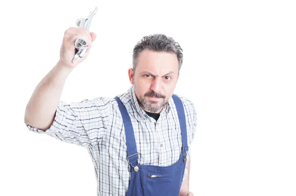 Angry expression of young mechanic using wrench as a weapon Stock Image