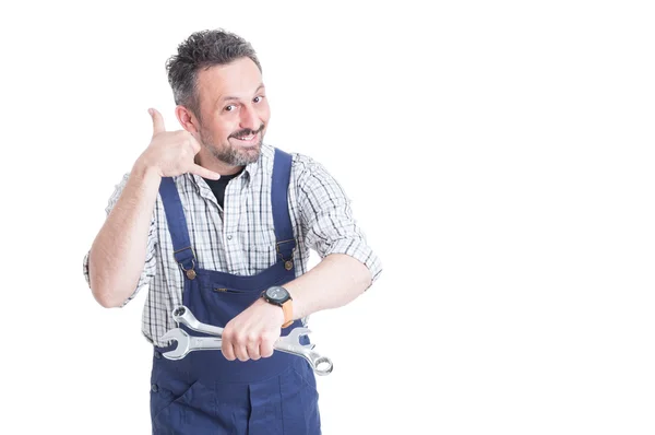 Hombre sonriente en overol haciendo un gesto de llamarme — Foto de Stock