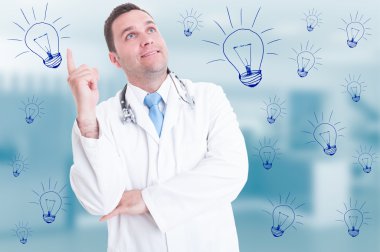 Happy smiling doctor pointing finger and looking up