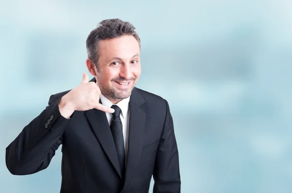 Joyful young salesman doing a call me gesture with hand — Stock Photo, Image