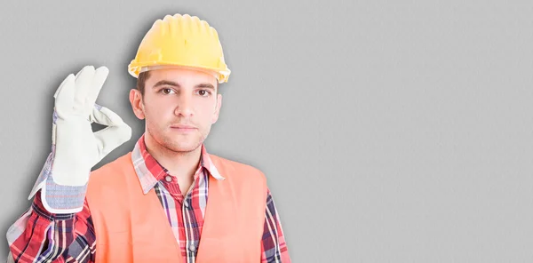 Schöner junger Bauarbeiter zeigt bei der Arbeit gutes Zeichen — Stockfoto