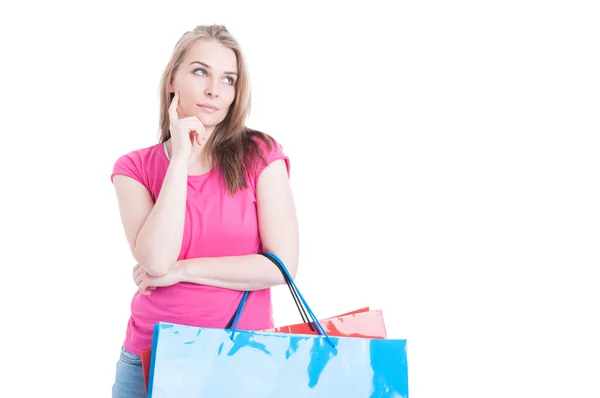 Beautiful young female at shopping thinking what to buy — Stock Photo, Image