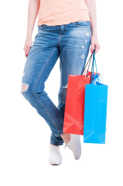 Woman wearing casual jeans and holding big paper shopping bags — Stock Photo, Image