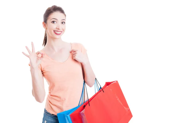 Hübsche Dame mit Einkaufstaschen lächelnd und Okay gestu zeigend — Stockfoto