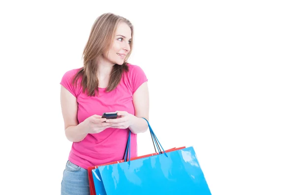 Sonriendo chica atractiva que trabaja en el teléfono inteligente y relajarse en sh —  Fotos de Stock