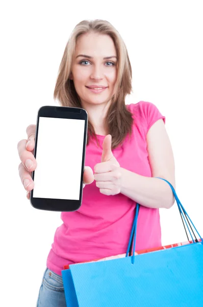 Young shopaholic holding phone with empty screen and showing thu — Φωτογραφία Αρχείου