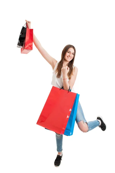 Shopping cheerful young woman holding colored bags over her head — Stock Photo, Image