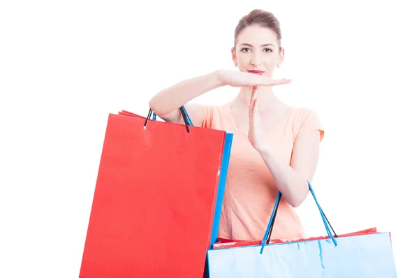 Mujer sosteniendo bolsas de compras haciendo tiempo fuera gesto — Foto de Stock