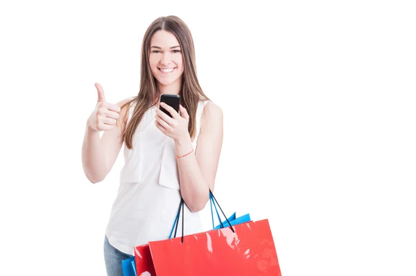 Mujer de compras moderna usando el teléfono móvil y pulgar hacia arriba — Foto de Stock