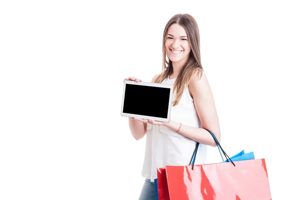 Mulher alegre com sacos de compras mostrando tablet com tela vazia — Fotografia de Stock