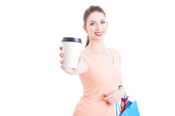 Frau mit Einkaufstaschen, die Papierkaffee zeigen oder anbieten — Stockfoto