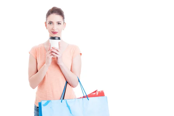 Mujer bonita llevando bolsas de compras y sosteniendo taza de papel de café —  Fotos de Stock