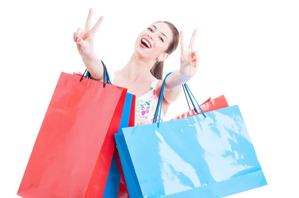 Woman at shopping with bunch of bags showing peace sign — Stockfoto