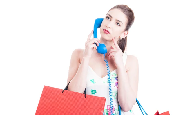 Junge Frau beim Einkaufen wartet in der Warteschleife am Telefon — Stockfoto