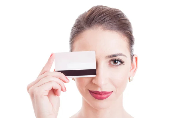 Cara de mujer joven con ojo cubierto por tarjeta de débito — Foto de Stock