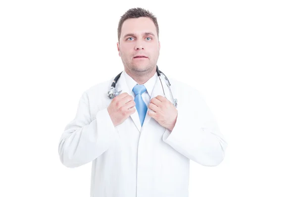 Médico varón de pie y ajustando la corbata con ambas manos —  Fotos de Stock