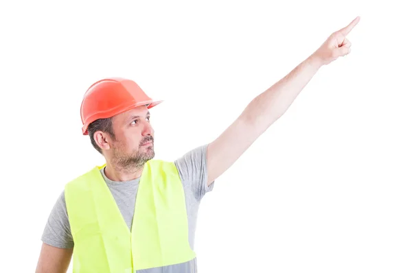 Atractivo constructor hombre apuntando con el dedo hacia arriba y mostrando algo —  Fotos de Stock