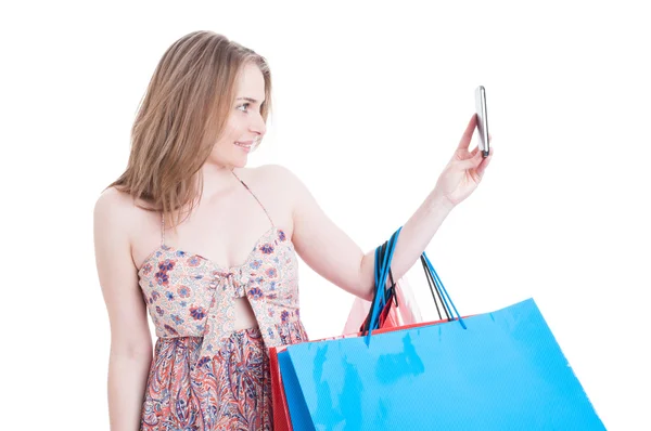 Beautiful smiling shopper with gift bags taking a selfie — Stock Photo, Image