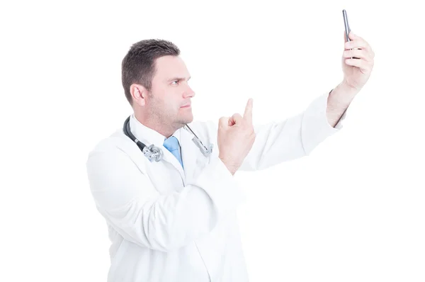Joven médico varón tomando selfie y mostrando el dedo medio —  Fotos de Stock
