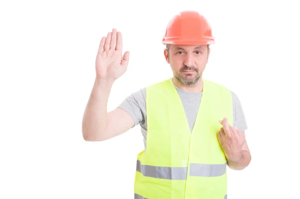 Constructor serio levantando su mano derecha y jurando falso — Foto de Stock
