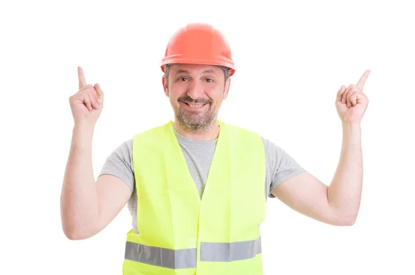 Joyful young builder pointing fingers to white copyspace — Stock Photo, Image