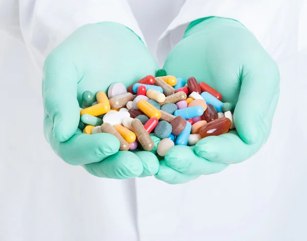 Gros plan des mains tenant un tas de pilules colorées — Photo