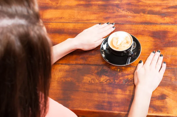 Женщина ждет на террасе с кофе в сторону — стоковое фото