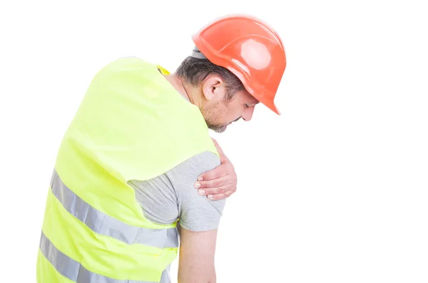Молодой строитель чувствует напряжение в правом плече — стоковое фото