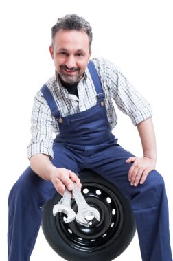 Neşeli teknisyen gülümseyen ve anahtar aleti gösteren