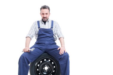 Araba lastiği üzerinde oturan spanner ile ciddi mekanik 