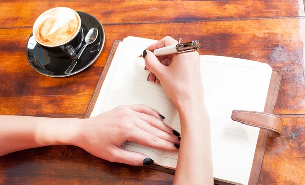 Mulher mãos escrevendo no caderno no terraço — Fotografia de Stock
