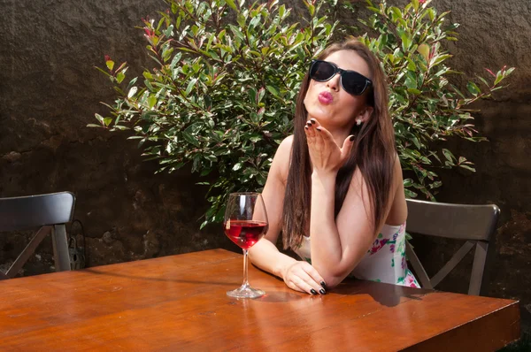 Menina bebendo vinho e soprando beijo no terraço — Fotografia de Stock