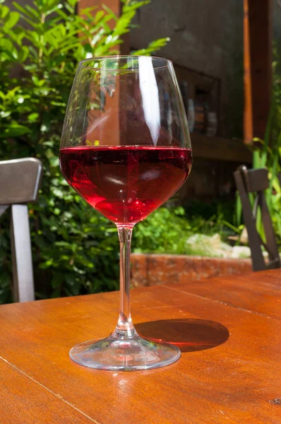 Copo de vinho na mesa do terraço de madeira — Fotografia de Stock