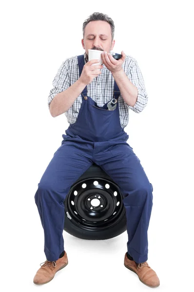 Young mechanic relaxing and enjoying fresh coffee — Stock Photo, Image