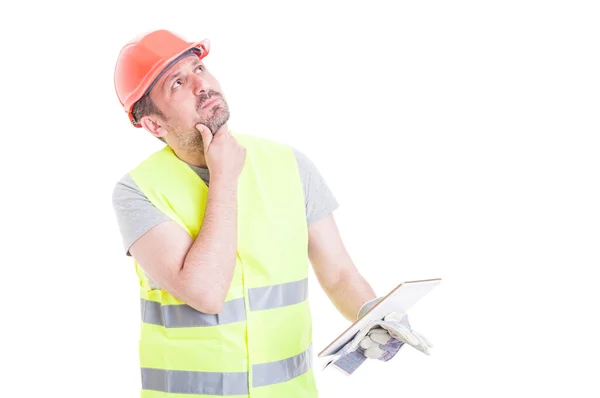 Pensive attractive constructor holding digital tablet in hand — Stock Photo, Image