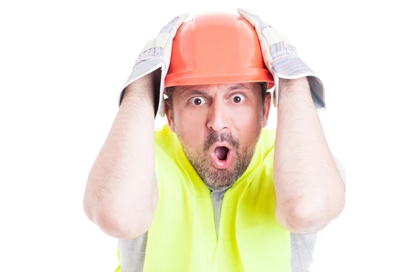 Sorprendido joven constructor sosteniendo su cabeza buscando desesperado — Foto de Stock