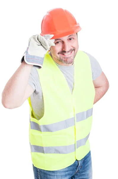 Construtor atraente homem segurando capacete agindo educado — Fotografia de Stock