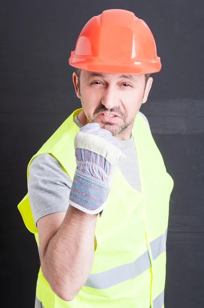 Wütender männlicher Bauarbeiter zeigt Faust und sieht irritiert aus — Stockfoto