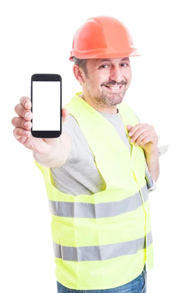 Sonriente constructor atractivo que sostiene el teléfono inteligente con pantalla en blanco —  Fotos de Stock