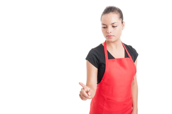 Young female market employee pointing something down — Stockfoto