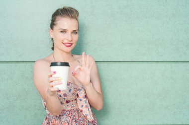 Bayan kahve bardağı gösteren ve mükemmel jest yapıyor