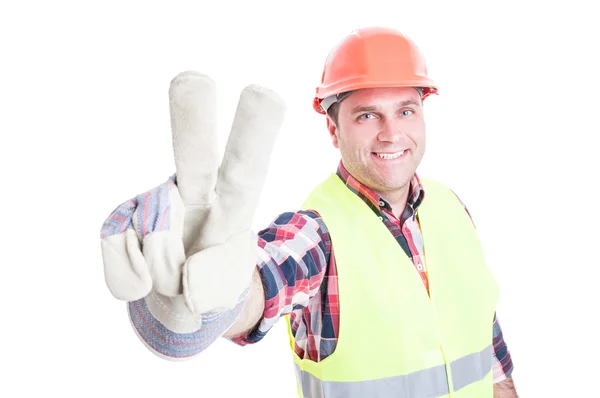 Fröhlicher Bauarbeiter, der Sieg oder Friedenszeichen tut — Stockfoto