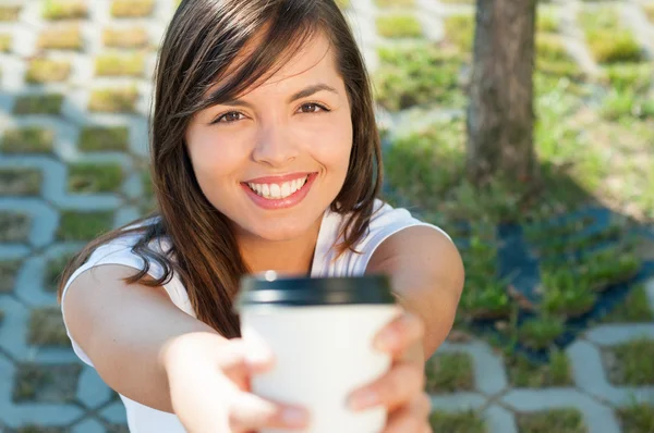 Hermosa dama sonriendo y ofreciendo una taza de café para llevar —  Fotos de Stock