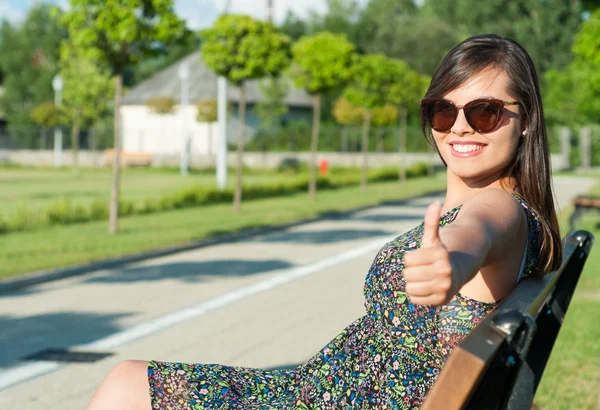 Jeune femme faisant comme geste assis sur le banc — Photo