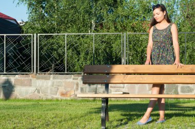 Güzel genç bayan park ayakta tezgah yanında poz