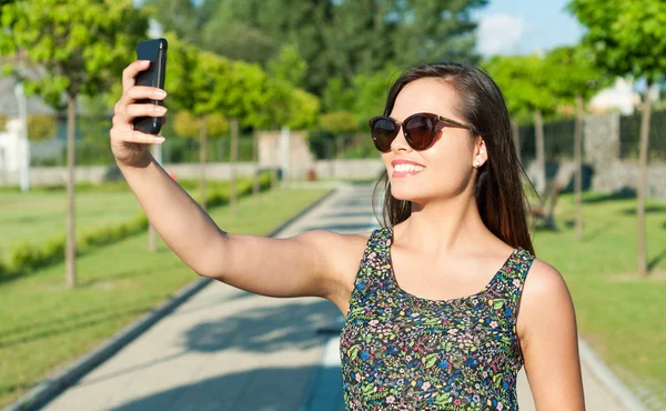 かなり女の子笑顔と公園で selfie を取って — ストック写真