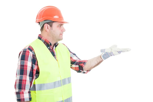 Jovem construtor mostrando algo na palma da mão aberta — Fotografia de Stock